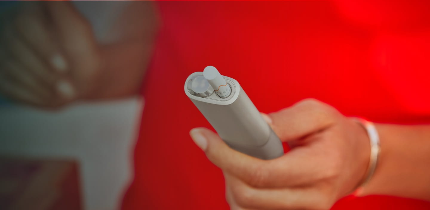 An IQOS ILUMA ONE device in a womans hand.